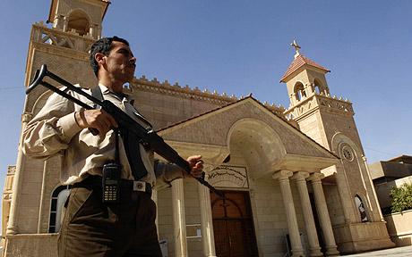 An armed man outside a cathedral in Kirkuk, Iraq. (Photo: AP)